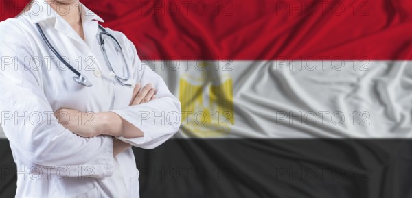 Doctor with crossed arms on Egypt flag. Egypt health and care concept. Female doctor on Egypt flag