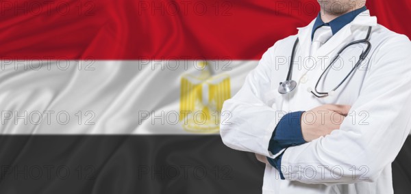 Egypt healthcare concept. Male doctor on Egypt flag. Doctor with crossed arms on Egypt flag