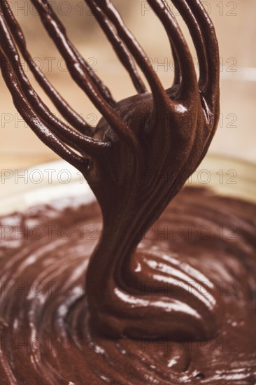 A bowl of chocolate dough, a whisk for whipping, baking, structure and consistency, homemade, top view, no people
