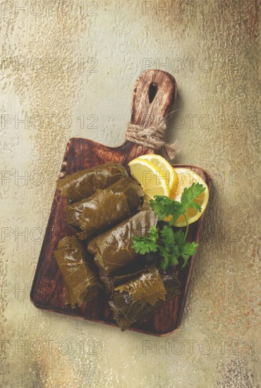 Dolma, minced meat with rice, in grape leaves, minced meat rolls, on a chopping board, top view, no people