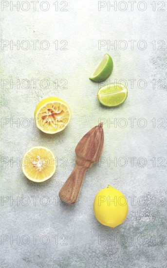 Wooden citrus reamer, manual lemon juicer, made of acacia wood, with citrus fruits on the table, top view