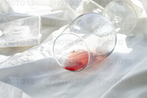 Glass, with pink wine, spilled on a white shirt, close-up, selective focus, no people, concept, top view