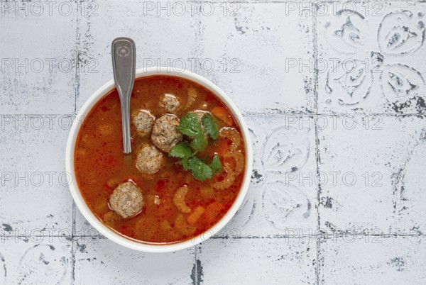 Romanian soup with meatballs, vegetable soup with meatballs, tiled table, homemade, no people