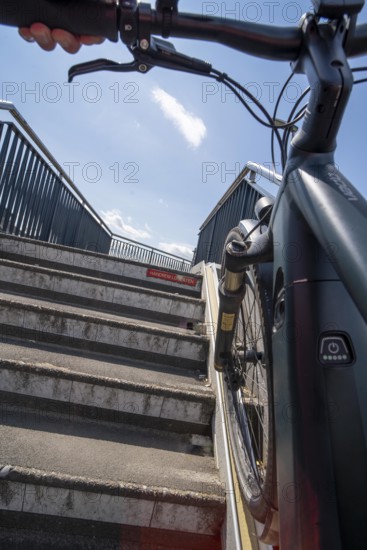 Staircase with bicycle channel, for pushing the bicycle, on the bicycle and pedestrian bridge Snelbinder Burg, over the river Waal near Nijmegen, was added to the existing railway bridge, fast cycle path connection from the city centre of Nijmegen and the new housing estates in the Waalsprong district, Netherlands