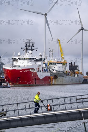 Working vessels in the seaport of Eemshaven, dredger Vitus Bering, aft, cable layer and offshore supply and working vessel Seaway Aimery, Netherlands