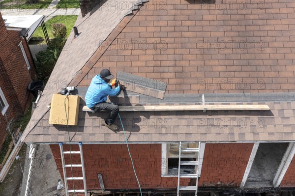 Detroit, Michigan - Workers re-roof a house they are remodeling in the Morningside neighborhood that had been vacant for many years. Detroit lost nearly two-thirds of its residents from 1950 to 2020 but has been growing modestly in recent years