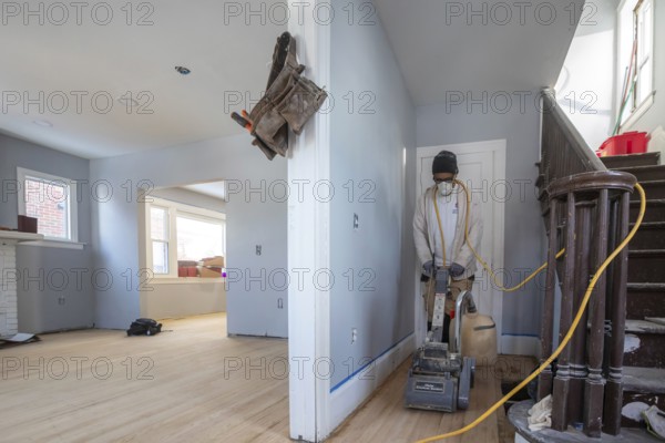 Detroit, Michigan - Workers sand a floor as they remodel a house in the Morningside neighborhood. The house had been vacant for many years. Detroit lost nearly two-thirds of its residents from 1950 to 2020 but has been growing modestly in recent years