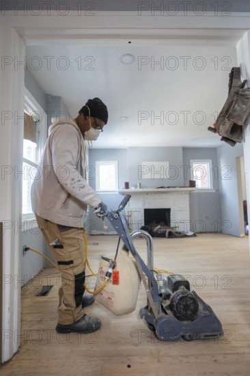 Detroit, Michigan - Workers sand a floor as they remodel a house in the Morningside neighborhood. The house had been vacant for many years. Detroit lost nearly two-thirds of its residents from 1950 to 2020 but has been growing modestly in recent years