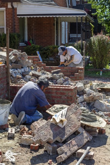 Detroit, Michigan - Workers rebuild the front porch of a house they are remodeling in the Morningside neighborhood. The house had been vacant for many years. Detroit lost nearly two-thirds of its residents from 1950 to 2020 but has been growing modestly in recent years