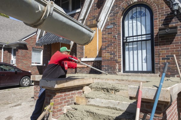 Detroit, Michigan, Workers rebuild the front porch of a house they are remodeling in the Morningside neighborhood. The house had been vacant for many years. Detroit lost nearly two-thirds of its residents from 1950 to 2020 but has been growing modestly in recent years