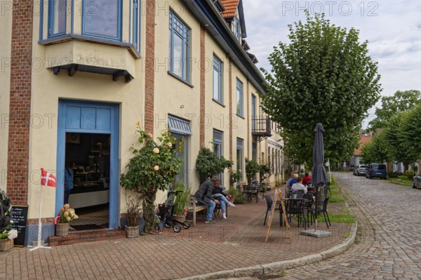Cafe in the town centre, on the corner of Neuer Damm and Lange Straße, both with cobblestones. Arnis, the smallest town in Germany. Arnis, Schleswig-Holstein, Germany