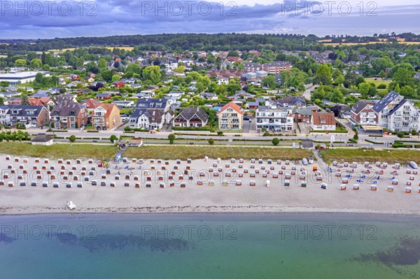 Aerial view over sandy beach with roofed wicker beach chairs and seaside resort Haffkrug along the Baltic Sea, Scharbeutz, Schleswig-Holstein, Germany