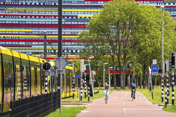 Cycle path through the university campus in Utrecht Science Park, Utrecht University, colourful facade of the Hogeschool Utrecht building, public transport, tram, Netherlands