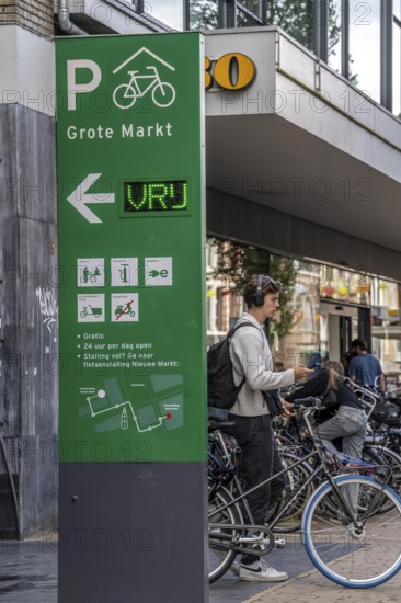 Cycling in the city centre of Groningen, old town, entrance to the bicycle parking garage at the Grote Markt, Netherlands
