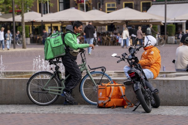 Bicycle transport in Groningen, Uber Eats, courier driver waiting for new orders, thuisbezorg.nl messenger with moped-style e-bike, Fatbike, Netherlands