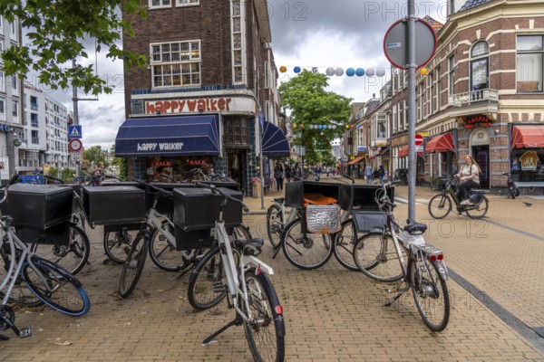 Riding a bike in the city centre of Groningen, old town, parked courier bikes, food delivery services, Netherlands