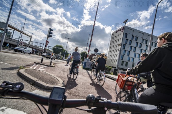 Cycling in the Dutch city of Utrecht, cycle path separated from the carriageway for cars, heavy traffic, Netherlands