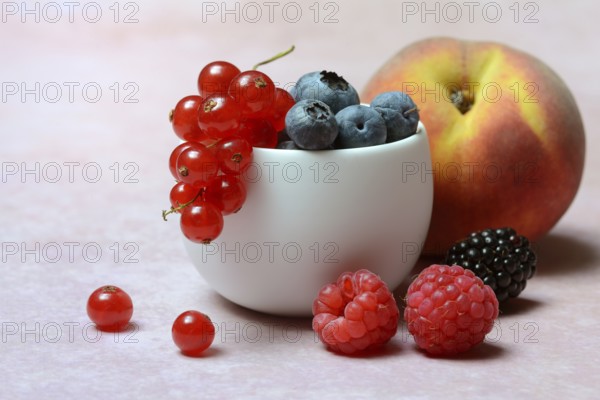 Various fruits in peel, redcurrant, peach, blueberry, blackberry, raspberry