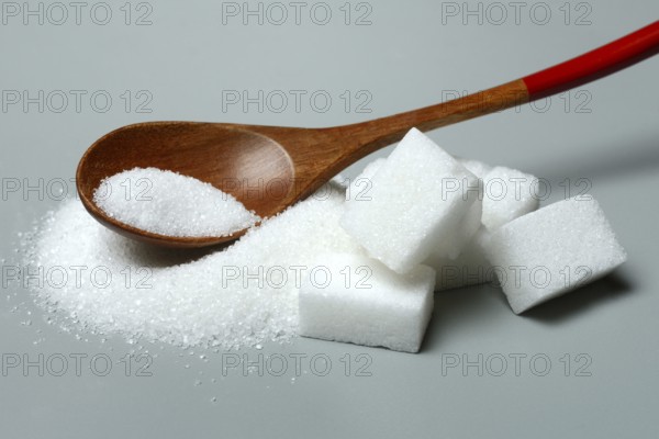 Sugar with wooden spoon and sugar cube