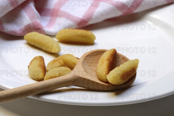Fried puff noodles with cooking spoon on plate