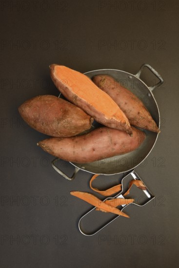 Sweet potatoes in skin with potato peeler, Ipomoea batatas