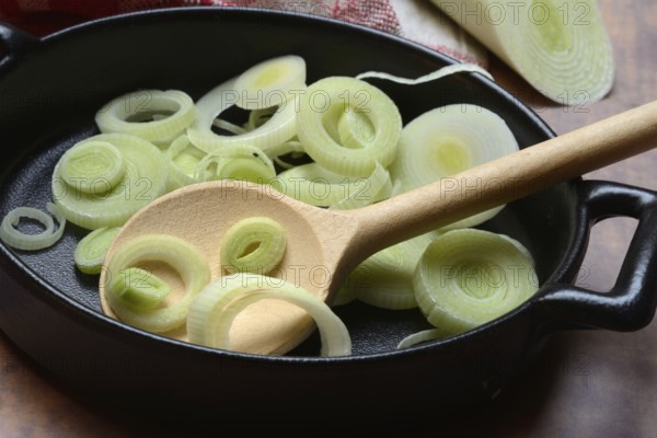 Leeks, leek rings in pan with cooking spoon, leek
