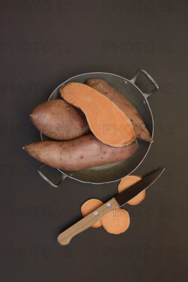 Sweet potatoes in their skins with kitchen knife, Ipomoea batatas