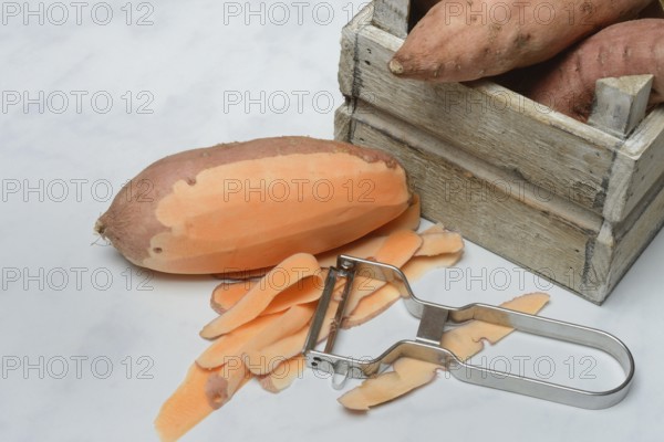 Sweet potato with vegetable peeler, partly peeled, Ipomoea batatas