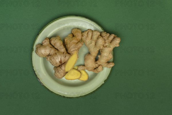 Ginger tubers and ginger slices on plate, Zingiber officinale