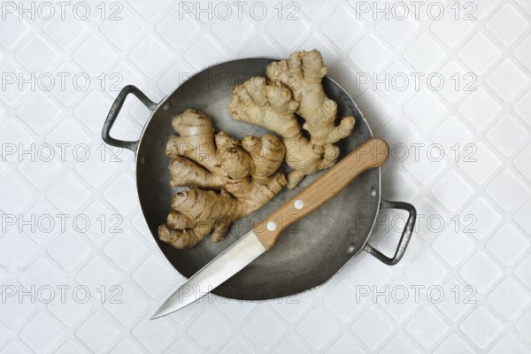 Ginger, ginger tubers in bowl with kitchen knife