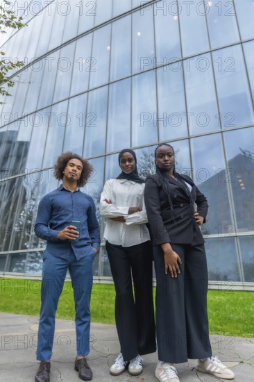 Young diverse business team standing together with confidence outdoors, reflecting professionalism, ambition, and collaboration in a contemporary urban environment