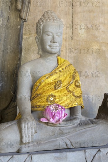 Sandstone Buddha statue, (Bhumispara mudra: Buddha Gautama at the moment of enlightenment), with tunic and lotus flower, Angkor Wat, Angkor Archaeological Park, Siem Reap, Cambodia