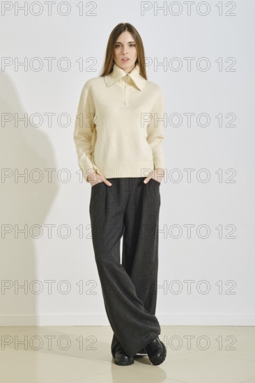 A young woman stands confidently in a stylish, cozy winter outfit that emphasizes convenience and practicality