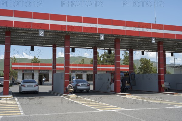 Gas station with red roof, numbered passages and parked cars, gas filling station, Sewan, Gegharkunik province, Armenia