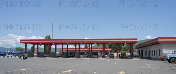 Large red gas station with several cars, pillars and adjacent building, gas filling station, Sewan, Gegharkunik province, Armenia