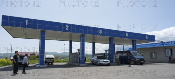 Covered gas station with numbered pillars, several vehicles and people, gas filling station, Sewan, Gegharkunik province, Armenia