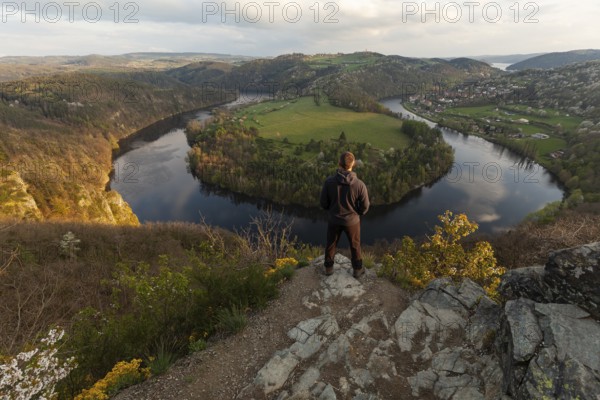 Man standing on a rock at sunset on spring evening at the loop of the Vltava (Vltava) View Solenice Central Bohemia Czech Republic