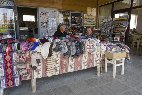 Two woman selling colorful hand-knitted clothes at a market stall, Noratus, Noradus, Gegharkunik province, Armenia