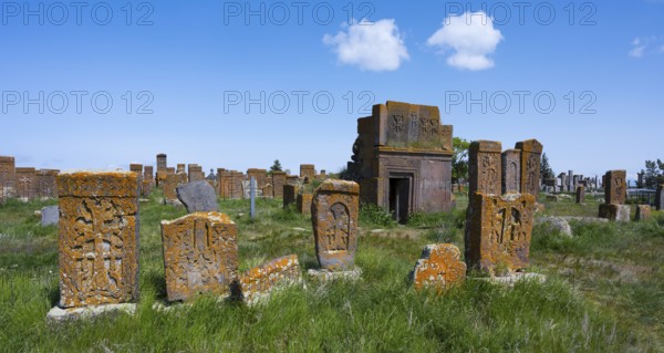 Ancient cemetery with decorated tombstones and a small building under a blue sky, crossstones, khachkars, world's largest khachkar field, Noratus cemetery, Noradus, Gegharkunik province, Armenia
