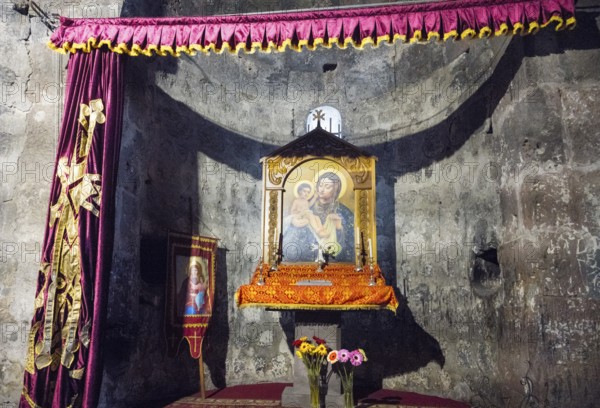 An altar with a religious icon surrounded by curtains and flowers in a decorated interior, Hajravank Monastery, Hayravank, Lake Sevan, Gegharkunik Province, Armenia