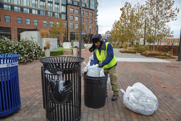 Washington, DC USA - 27 November 2025 - On Thanksgiving Day, a Hispanic worker is on the job picking up trash. He is working for the Capitol Riverfront Business Improvement District