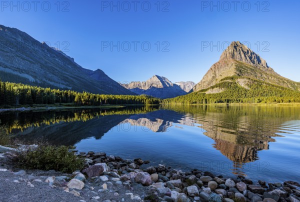 240831_066 Rippled reflection of the mountains on the calm waters of Lake Josephine in Glacier National Park, Montana, USA