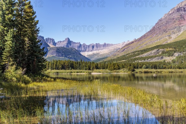 240831_325 Rugged Mountains rise up behind Swiftcurrent lake in Glacier National Park, Montana, USA