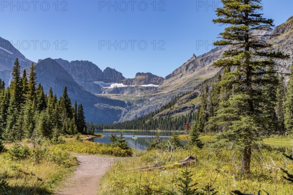 240831_277 Couple canoing on Josephine Lake surrounded by the rugged mountains of Glacier National Park, Montana, USA