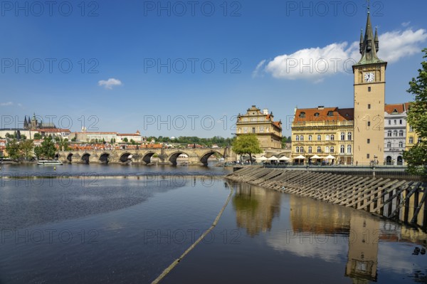 Vltava embankment with Old Town Water Tower, Novotný Bridge and Charles Bridge in Prague, Czech Republic