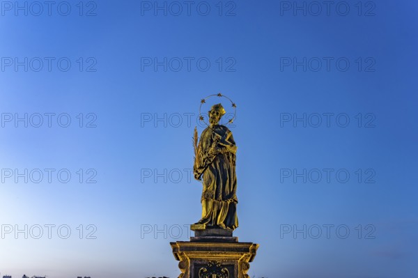 Saint John Nepomuk on Charles Bridge at dusk, Prague, Czech Republic