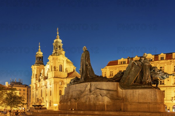 The Baroque St. Nicholas Church and the Jan Hus Memorial on Old Town Square at dusk, Prague, Czech Republic
