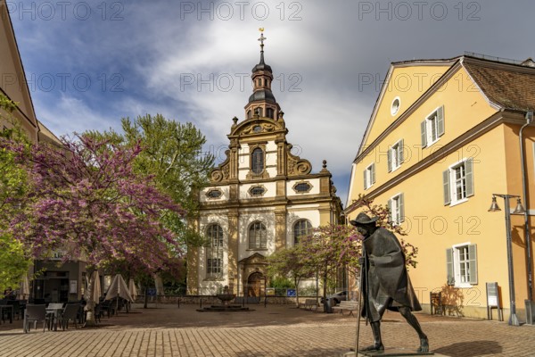 Sculpture of a Saint James Pilgrim on Maximilianstraße and the Trinity Church in Speyer, Rhineland-Palatinate, Germany
