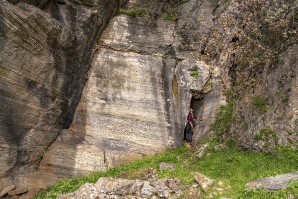 Tourist in the quarry near the prehistoric Palli-Lakka dragon houses Drakospita near Styra, island of Euboea or Evia, Greece