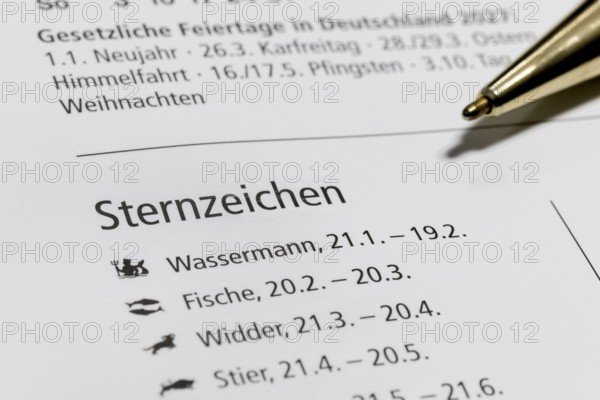 Calendar with information about zodiac signs, including Aquarius and Pisces, ballpoint pen